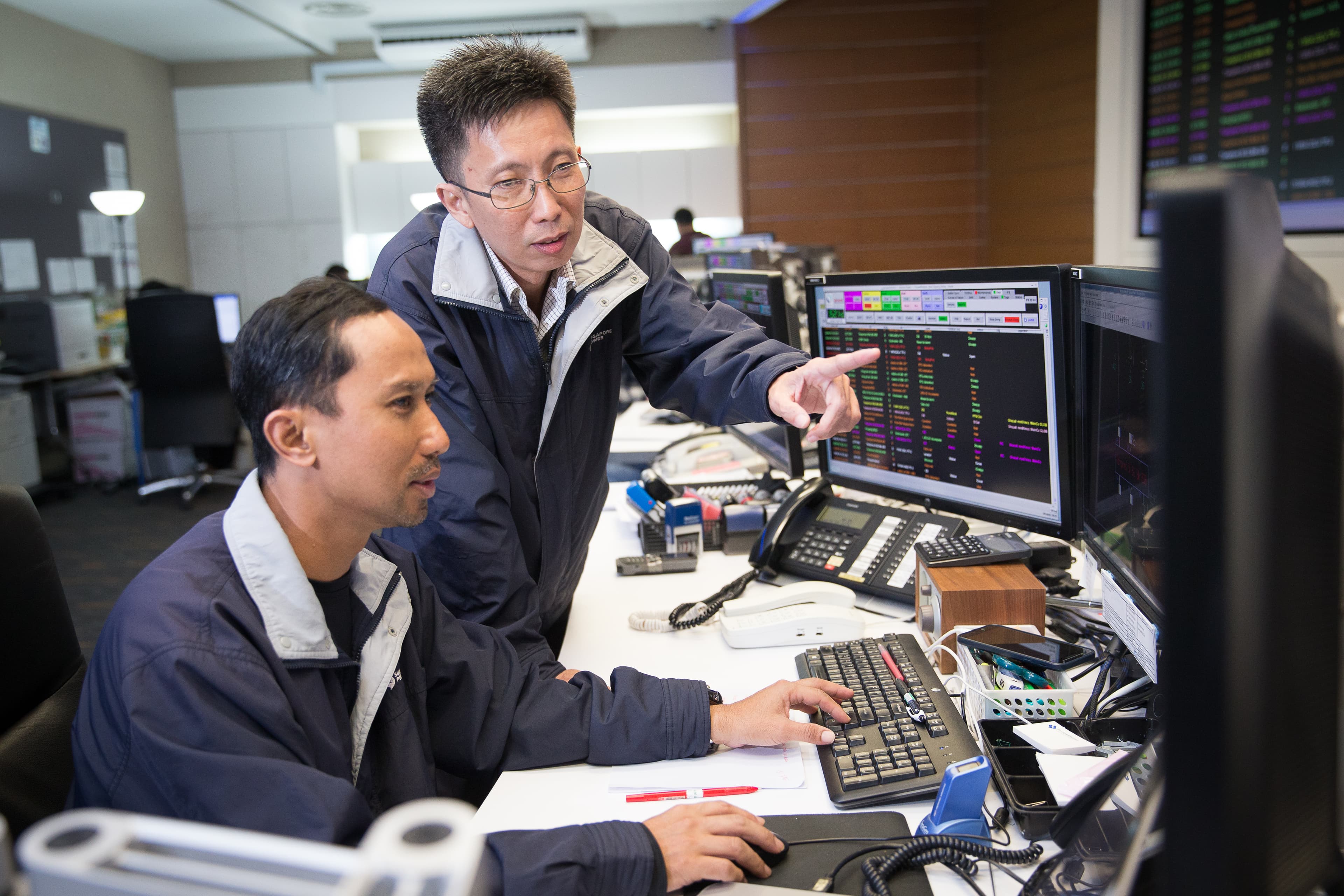 Mr Tan Teck Wee, Head, Distribution Control & Customer Service (standing), with Principal Operation Officer Ghazali Bin Mohamed Rahim in the Distribution Control Centre.