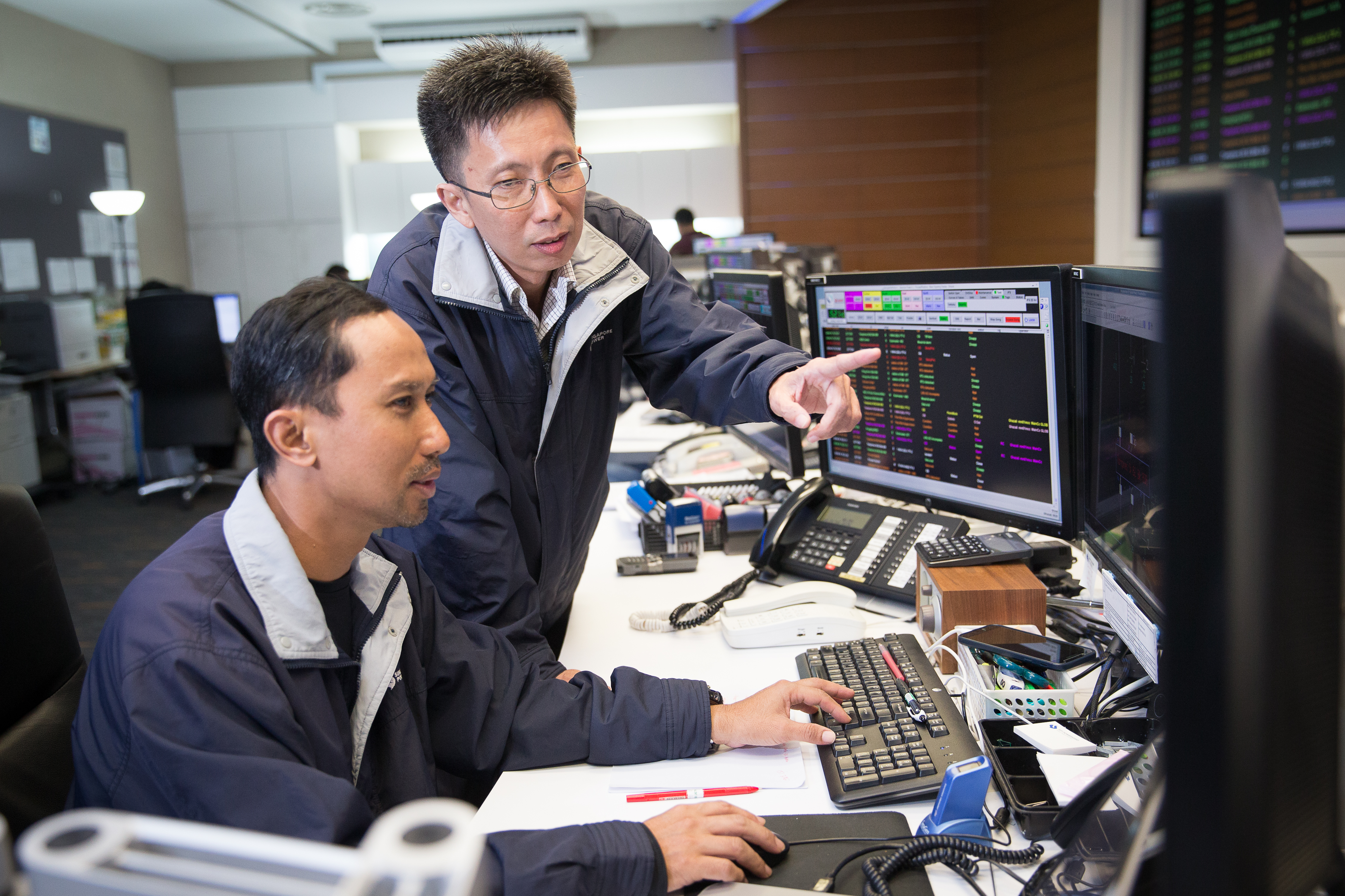 Mr Tan Teck Wee, Head, Distribution Control & Customer Service (standing), with Principal Operation Officer Ghazali Bin Mohamed Rahim in the Distribution Control Centre.